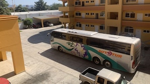 A multi-story building with a bus parked in front. - BONADAY HOTEL (Ometepec)