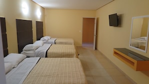 A hotel room with three beds, a TV mounted on the wall, and a small desk with a mirror. - BONADAY HOTEL (Ometepec)