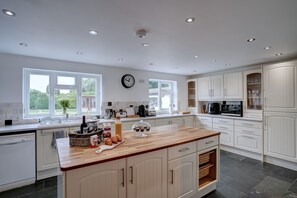 Enjoy cooking in this well-equipped kitchen with a central island, ample counter space, and large windows offering views of the surrounding area.