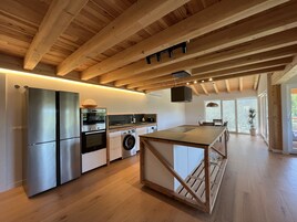 Una cocina moderna con vigas de madera, electrodomésticos de acero inoxidable y una isla central.