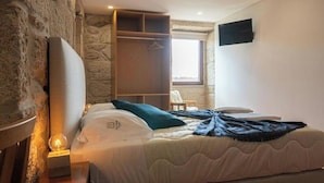 Ein Schlafzimmer mit Bett, Nachttischlampe, Kleiderschrank und Fenster.