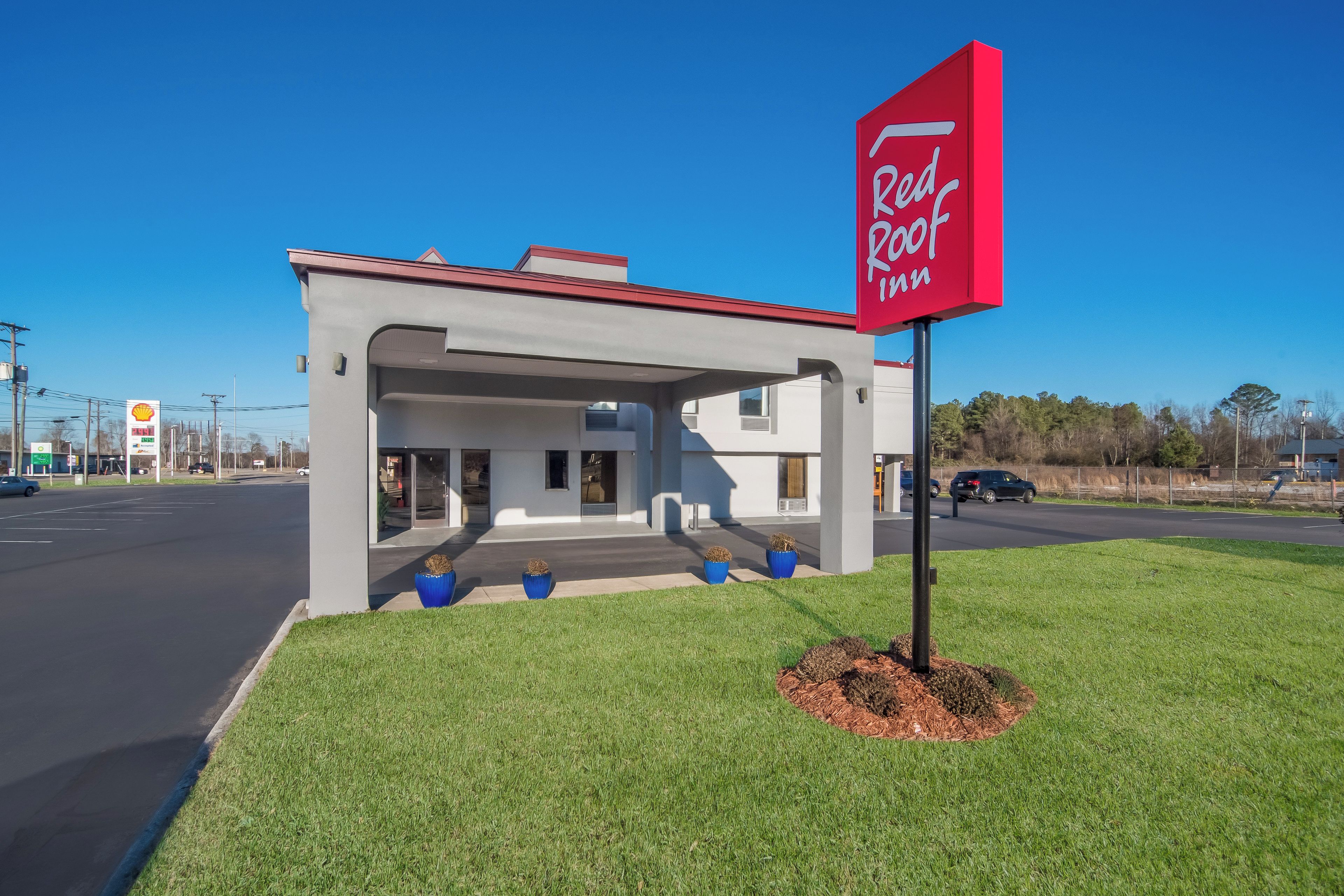 Un hôtel Red Roof Inn au design moderne, doté d’une entrée abritée et d’un parking.
