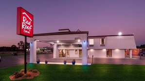 A Red Roof Inn with a modern design, featuring a covered parking area and a well-lit entrance. - Red Roof Inn Rocky Mount - Battleboro (Battleboro)