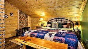 Cozy bedroom with a large bed, wooden bench, and rustic charm.