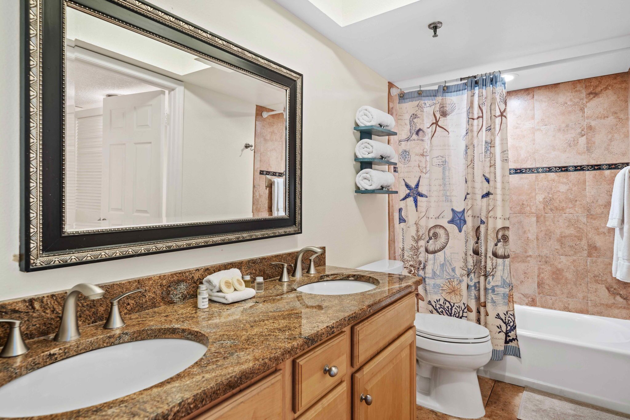 A bathroom with two sinks, a toilet, and a bathtub.