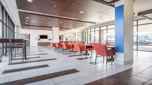 A modern dining area with a long table, chairs, and a television mounted on the wall. - Holiday Inn Express & Suites Platteville (Platteville)