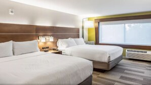 A hotel room with two beds, a nightstand, a lamp, a window, and an air conditioning unit. - Holiday Inn Express & Suites Platteville (Platteville)