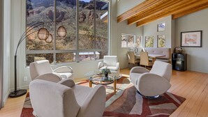 Un salon spacieux doté de grandes fenêtres, d’un ventilateur de plafond et d’un aménagement intérieur moderne.