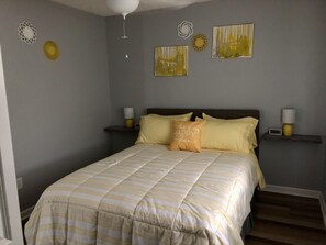Une chambre à coucher avec un lit, des tables de chevet et des éléments décoratifs sur les murs.