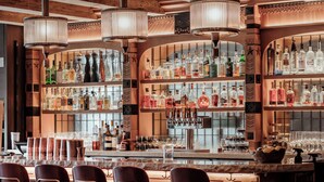 Eine Bar mit Holzmöbeln, einer Auswahl an Flaschen und einer rustikalen Atmosphäre.