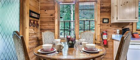 Enjoy meals in this inviting dining area with a round table for four, surrounded by matching chairs and a unique stained glass light fixture above.