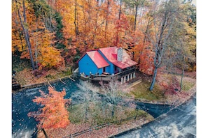 Escape to a cozy cabin nestled in a forest, offering a sheltered porch and a peaceful retreat.
