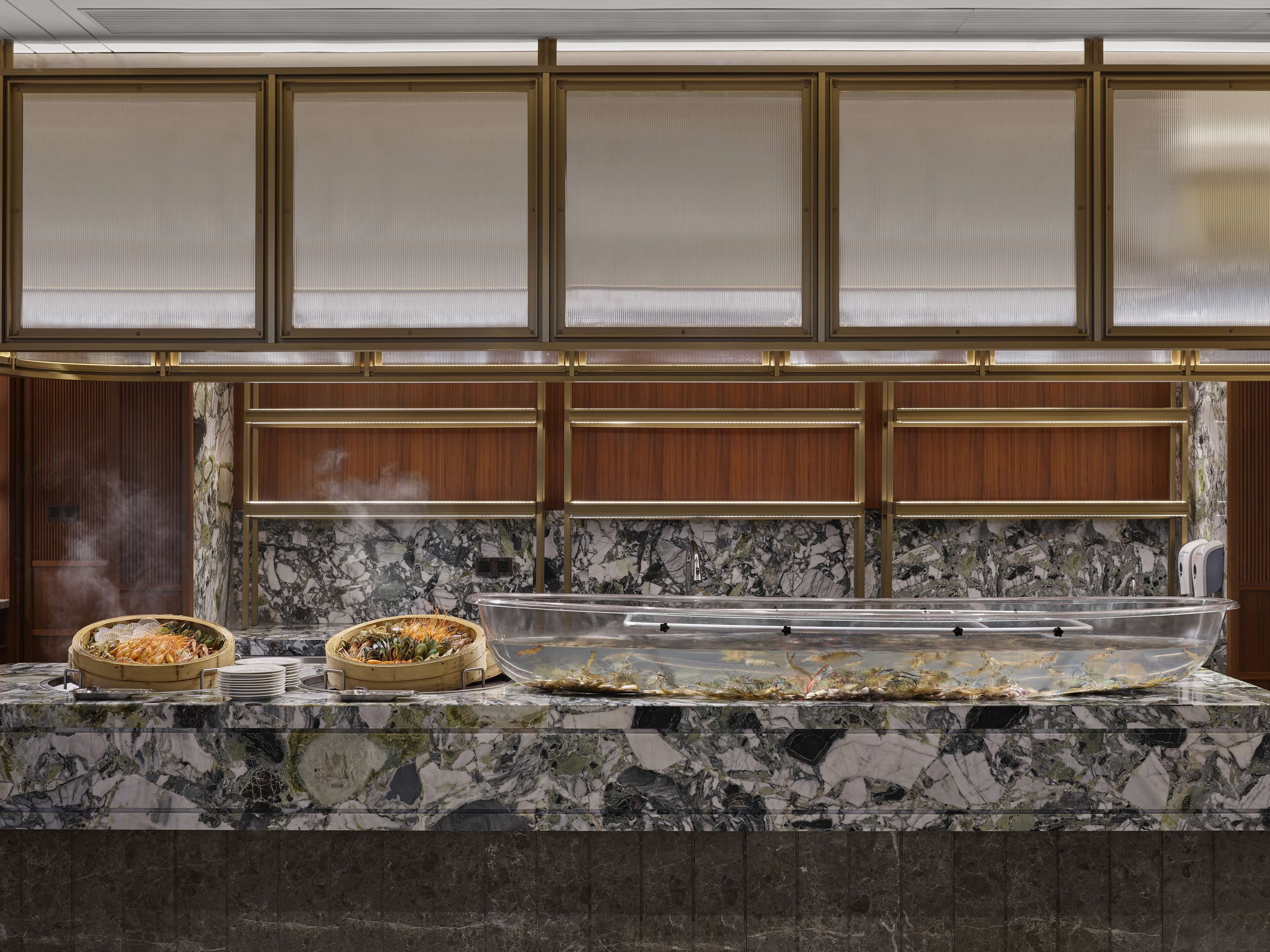 A marble countertop with seafood dishes and a glass container.