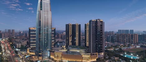 A high-rise hotel with multiple floors, a prominent entrance, and a pool area.