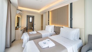 A hotel room with two beds, a desk, a chair, and a bathroom visible through an open door. - Seatown Hotel (Kas)