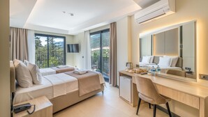 A hotel room with a bed, a desk, a chair, a small fridge, a telephone, a mirror, and a TV. - Seatown Hotel (Kas)