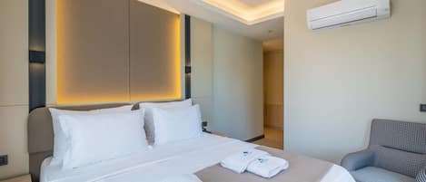 Una habitación de hotel moderna con una cama bien hecha, un sillón a cuadros y un aire acondicionado de pared.