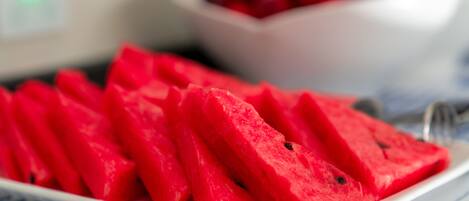 A white plate with watermelon slices on a checkered tablecloth.