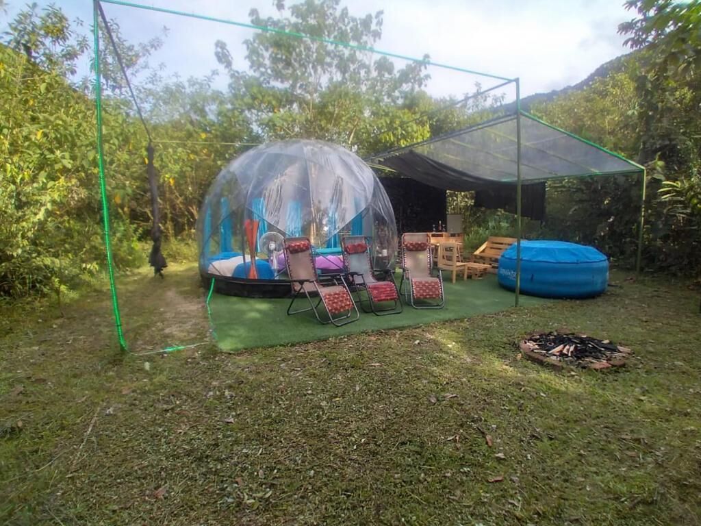 A covered outdoor area with a trampoline, seating, and a fire pit.