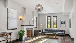 A spacious living room with a fireplace, a large gray sofa, and a coffee table.
