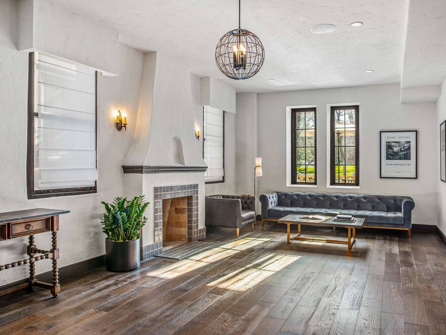 A spacious living room with a fireplace, a large gray sofa, and a coffee table.