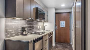A compact kitchen with a microwave, coffee maker, and dishwasher.