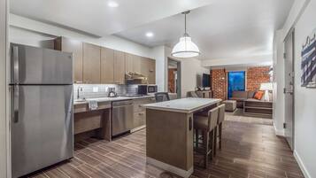 A modern kitchen with a central island, stainless steel appliances, and wooden cabinets.