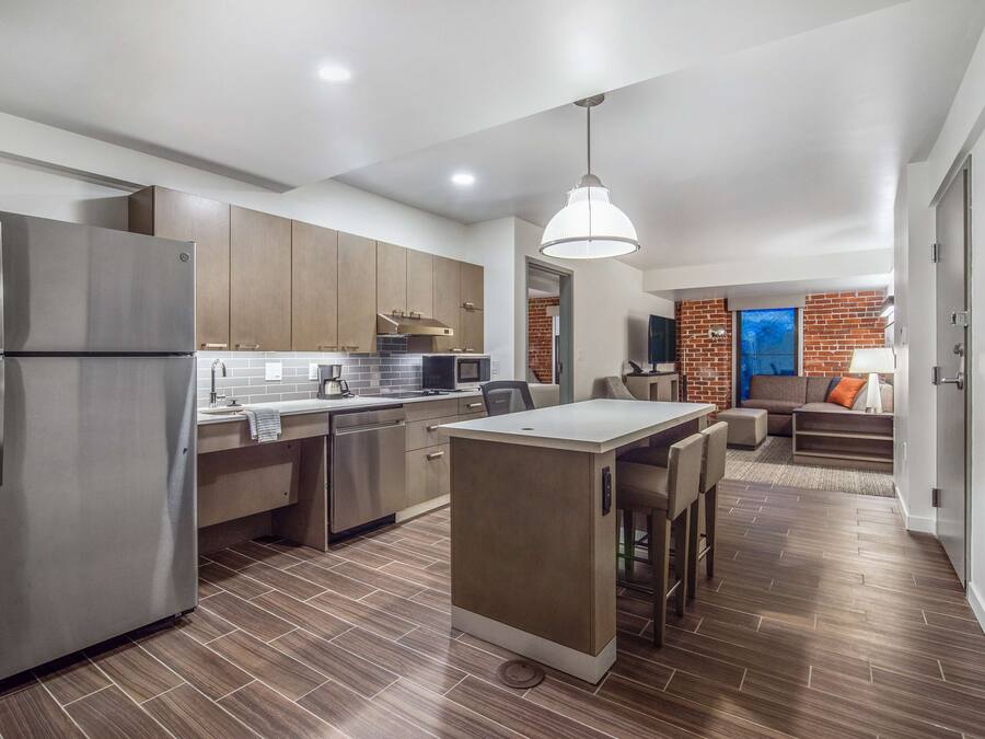 A modern kitchen with a central island, stainless steel appliances, and wooden cabinets.
