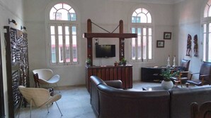 A spacious living room with a fireplace, comfortable seating, and large windows. - Hotel Central Recife (Recife)