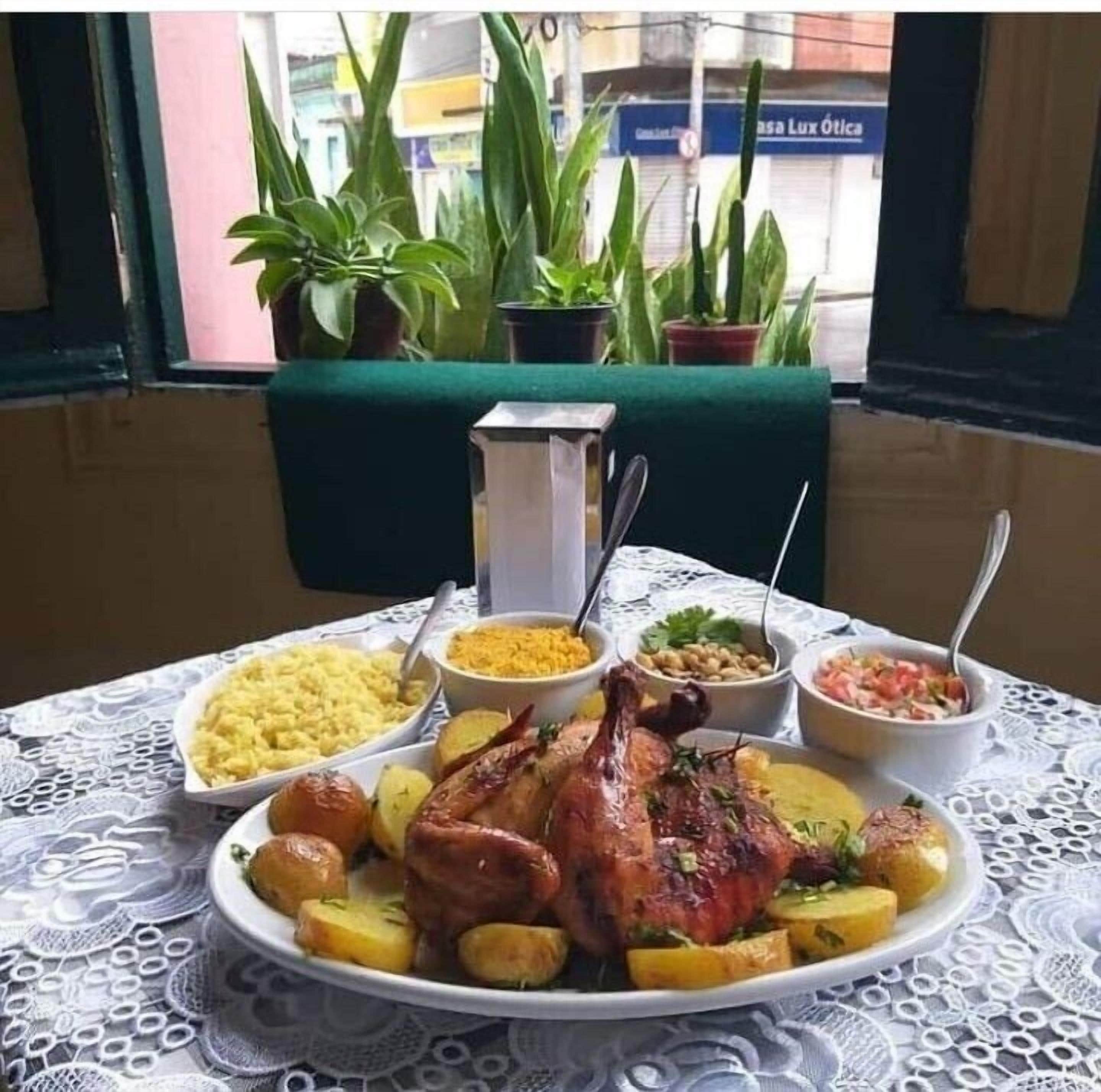 Ein Tisch mit gebratenem Huhn, Kartoffeln und verschiedenen Beilagen.
