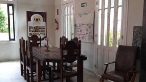 A dining area with a wooden table and chairs, a bulletin board, and a sign indicating a hotel. - Hotel Central Recife (Recife)