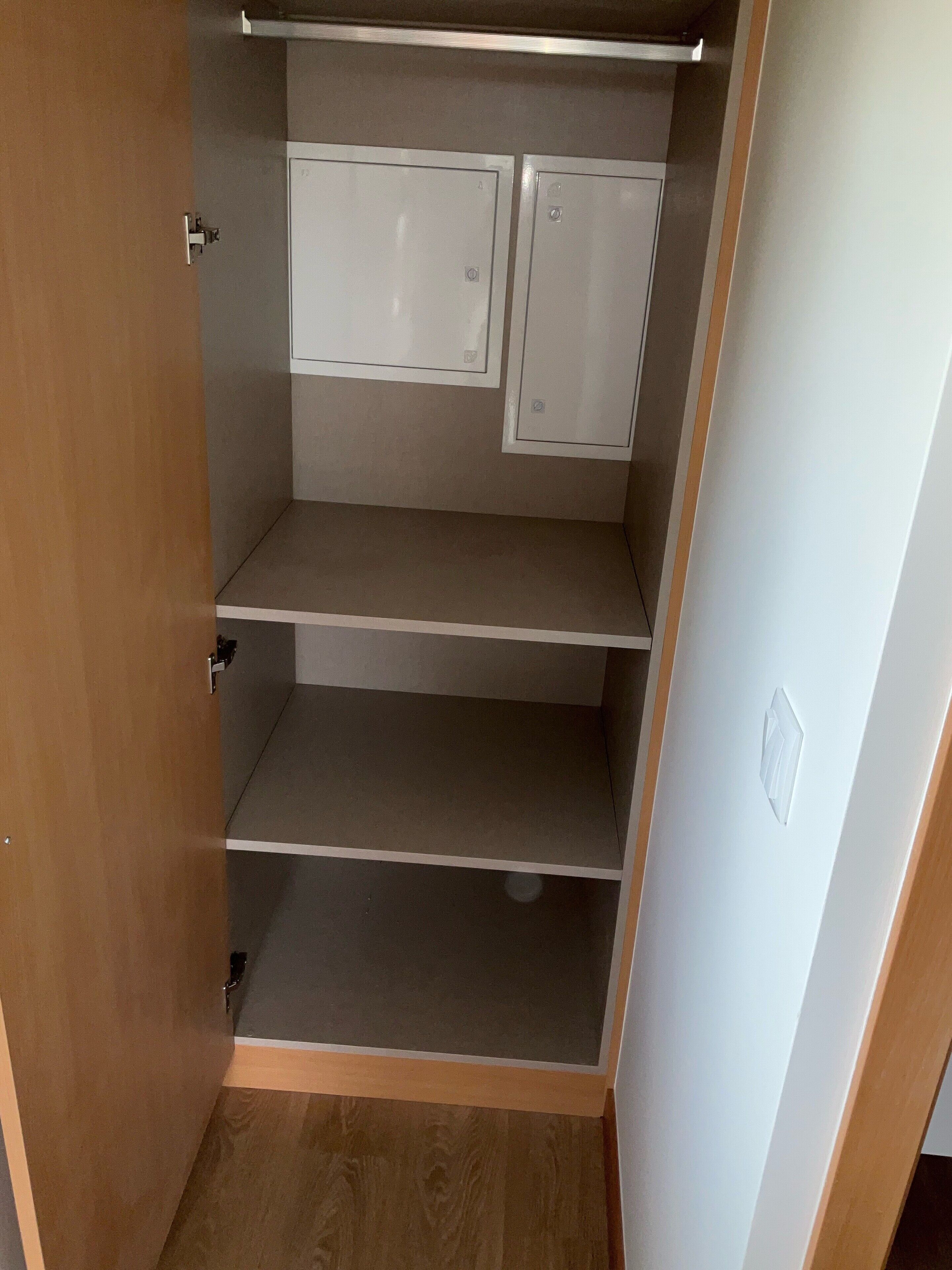 A closet with three shelves and two cabinets.