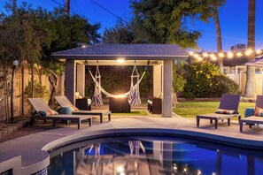 A covered outdoor seating area with hammocks and lounge chairs by a pool. - Charming 3 bd/2ba home - KING bed w/ non heated POOL near Old Town Scottsdale!   (Scottsdale)