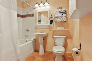 Ein Badezimmer mit Badewanne, Waschbecken, Toilette und Duschbereich.