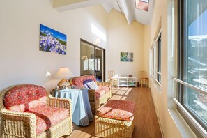 Relax in this serene room with a high ceiling, skylight, and comfortable seating area.