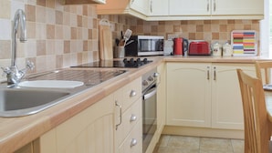 A kitchen with a sink, stove, microwave, toaster, and cabinets. - 2 bedroom accommodation in Narberth (Narberth)