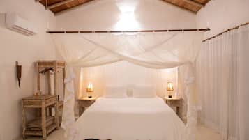 A bedroom with a canopy bed, wooden furniture, and bedside lamps.