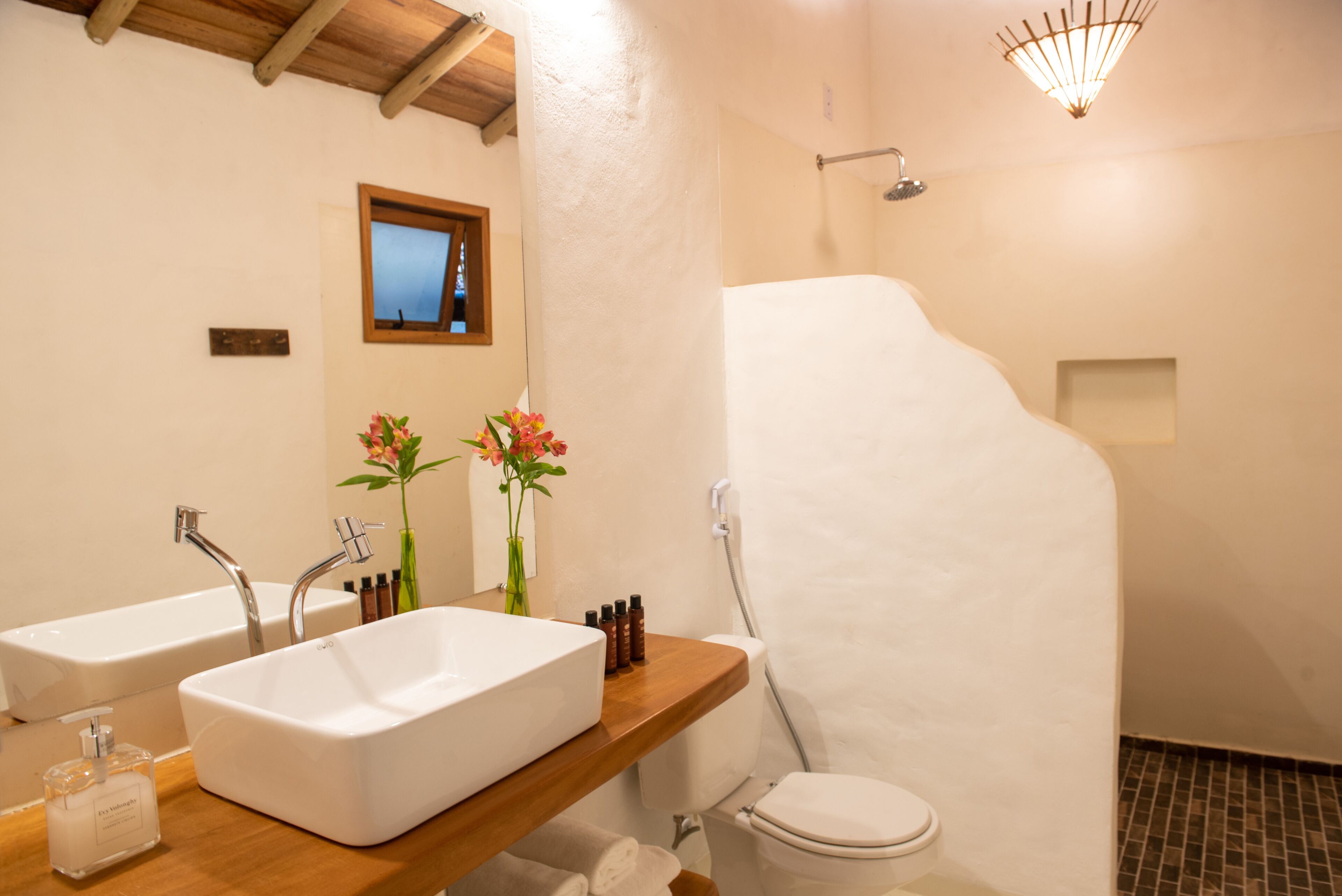 A bathroom with two sinks, a toilet, and a shower.