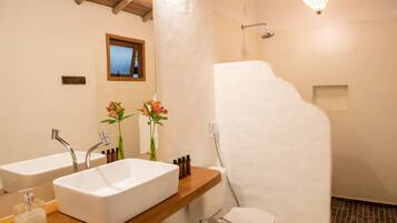 Un baño con dos lavamanos, inodoro y ducha.