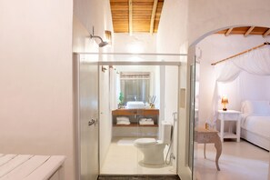 Een moderne badkamer met een douchecabine van glas, een wit toilet en een wastafel met spiegel.