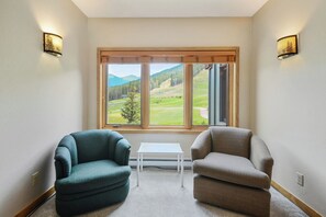 Enjoy a mountain view from the comfort of this room, featuring a seating area with two chairs and a small table.