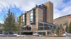 Stunning building with a glass and brown facade, featuring a prominent entrance and a sign.