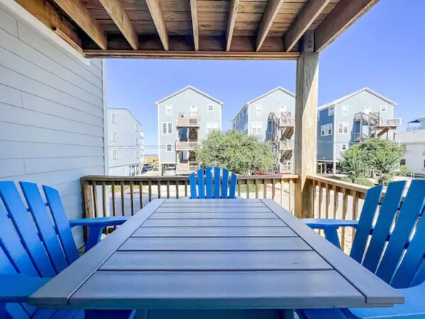 Relax in a serene outdoor space with a table and comfortable seating, taking in the views of the surrounding residential area.