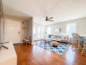 Cozy living area with a sofa, ottoman, dining table, and chairs.