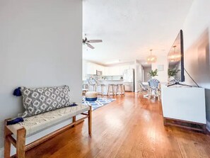 Relax in this open-plan living space with a kitchen area, featuring a central island and flat-screen TV.