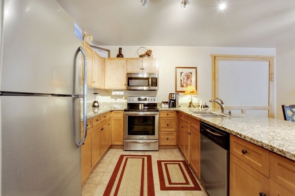 Enjoy cooking in this well-equipped kitchen with a refrigerator, microwave, oven, and dishwasher.