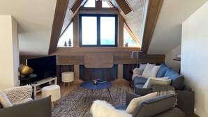 A spacious loft with a high ceiling, a fireplace, a large window, and modern furniture. - B306 - 79 m2 - 4P - 8 pers (Prapoutel)