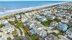 Un área residencial costera con casas, una playa y una vista despejada del océano.