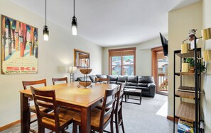 Relax in this stylish living space with a dining area, comfortable sofa, and large window offering a view of the surrounding area.