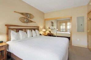 Relax in comfort with a large bed and ample pillows, complemented by a wall-mounted mirror and convenient door access.